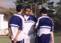 Coach Ned Gallagher huddles with one of his doubles teams during a changeover.